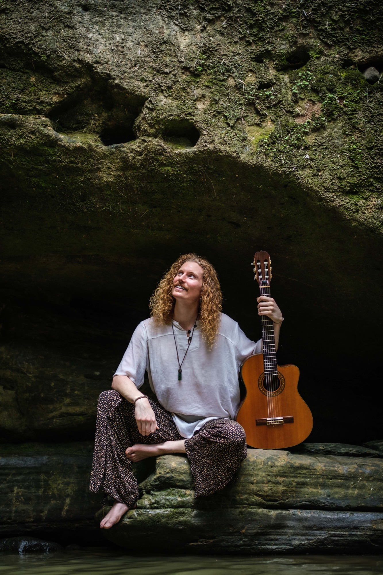 Alexander with his guitar in a cave.