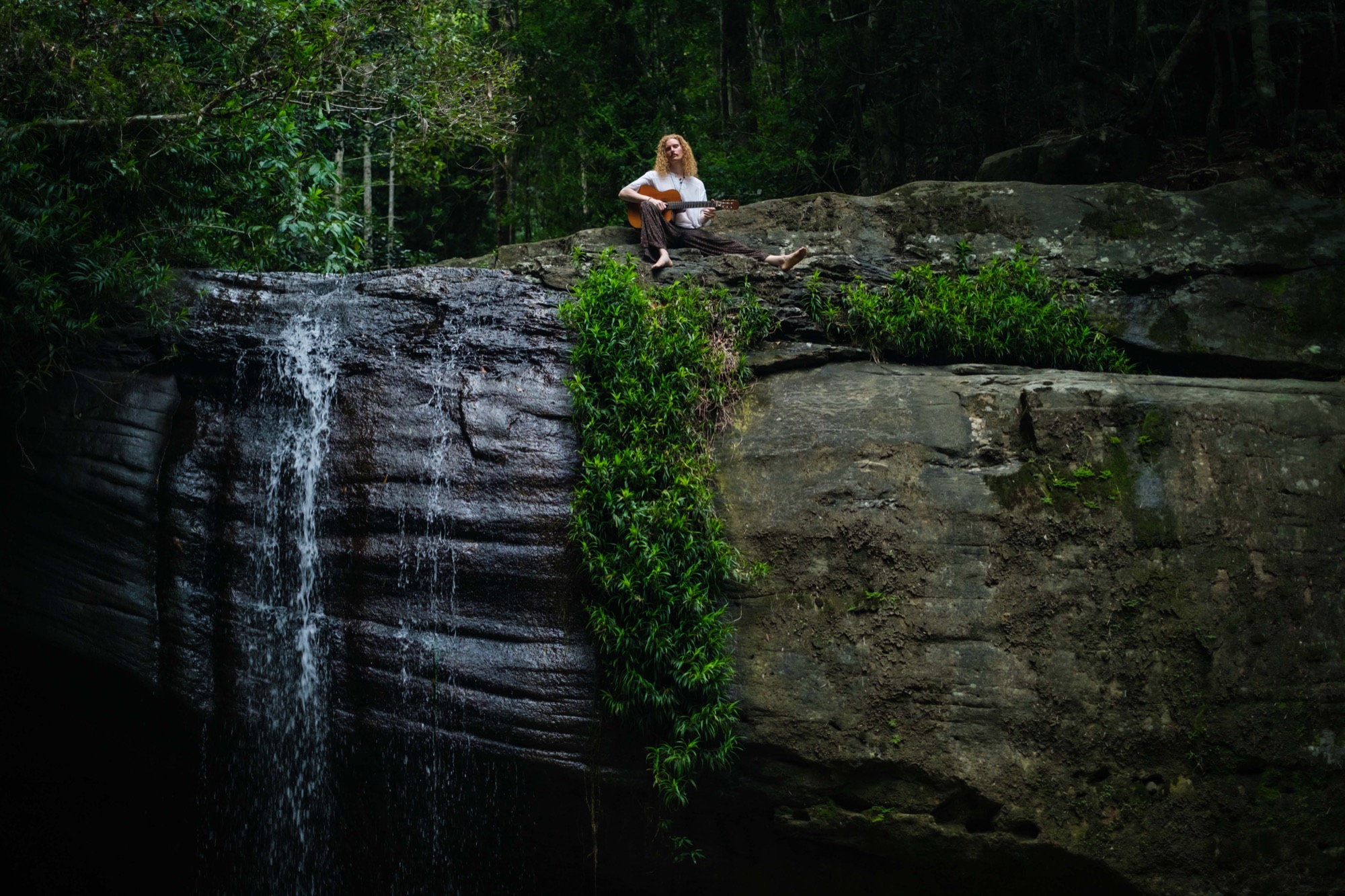 A rainforest pool and surrounding rock, an outdoor gathering place.